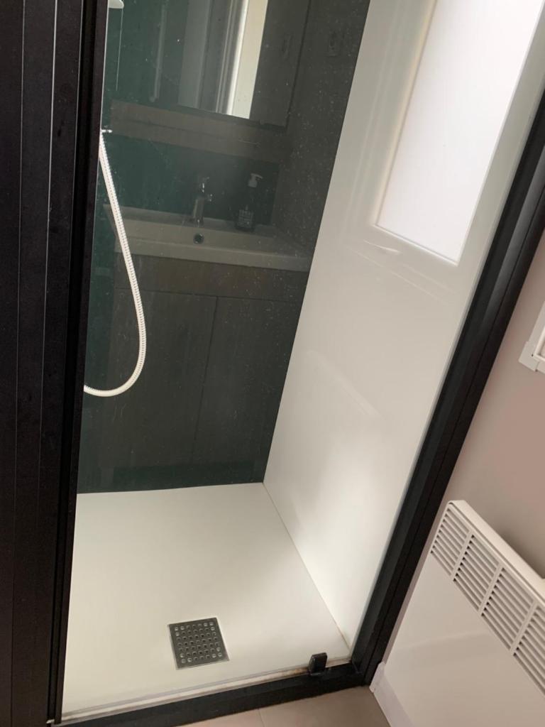 La salle de bains est pourvue d'une douche, d'une fenêtre et d'un lavabo. dans l'établissement Siblu Village Les Viviers Bassin d'Arcachon mobile home neuf climatisé 3 chambres, à Lège-Cap-Ferret
