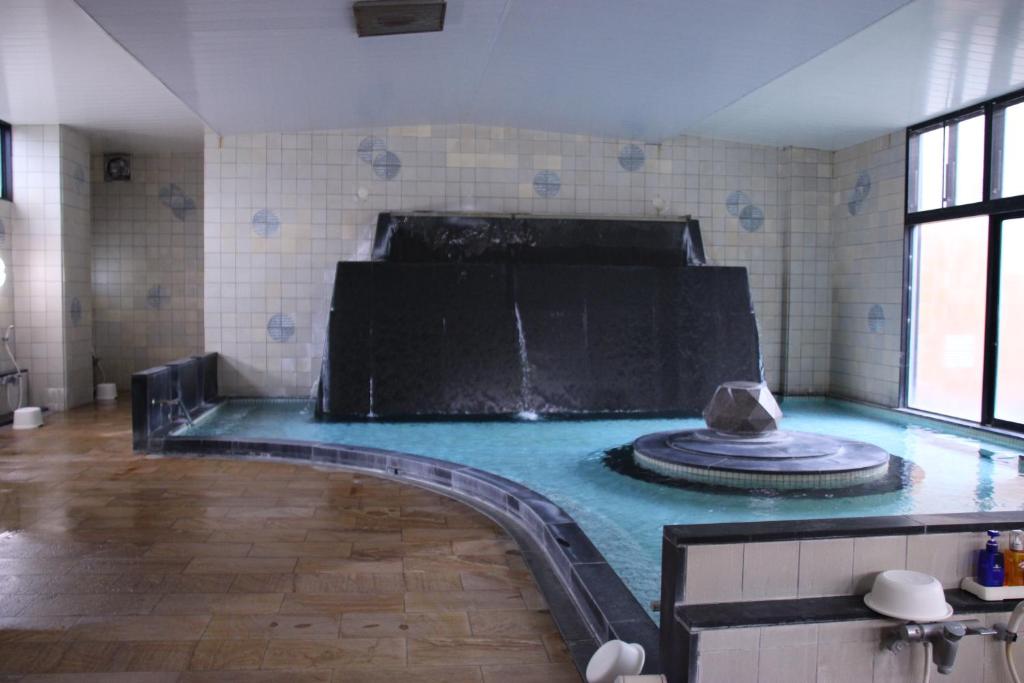 - une piscine dans une pièce dotée d'une fontaine dans l'établissement 楽気ハウス甲斐路 Raki House KAIJI, à Fuefuki