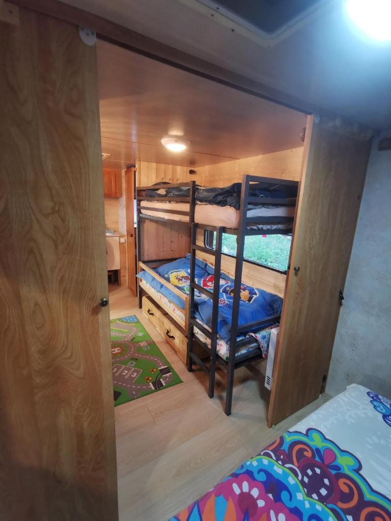 Cette petite chambre offre une vue sur une chambre dotée de lits superposés. dans l'établissement Caravane 4 personnes au camping d'Aussois, à Aussois 23 autres photos