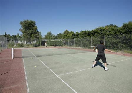 2 personnes jouant au tennis sur un court dans l'établissement Mobil home 4 personnes avec clim, à La Roque-dʼAnthéron