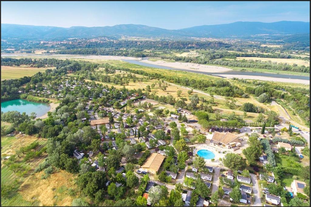 une vue aérienne d'une station balnéaire avec une rivière et des arbres dans l'établissement Mobil home 4 personnes avec clim, à La Roque-dʼAnthéron