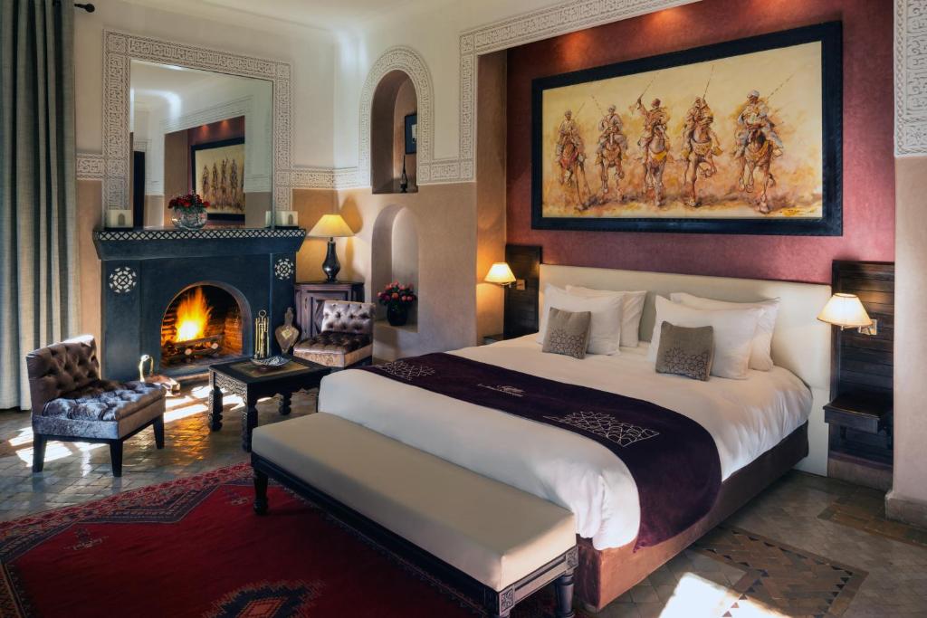 - une chambre avec un grand lit et une cheminée dans l'établissement Riad Monceau, à Marrakech