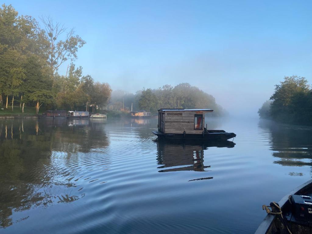 - un bateau sur une rivière avec une maison dans l'établissement Patouillet bateau naviguant, à Saint-Vincent-sur-Oust 6 autres photos