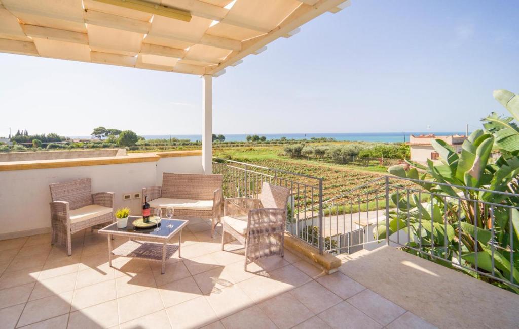 un patio avec des chaises et une table et une vue sur l'océan dans l'établissement Queen's Bay, à Porto Palo