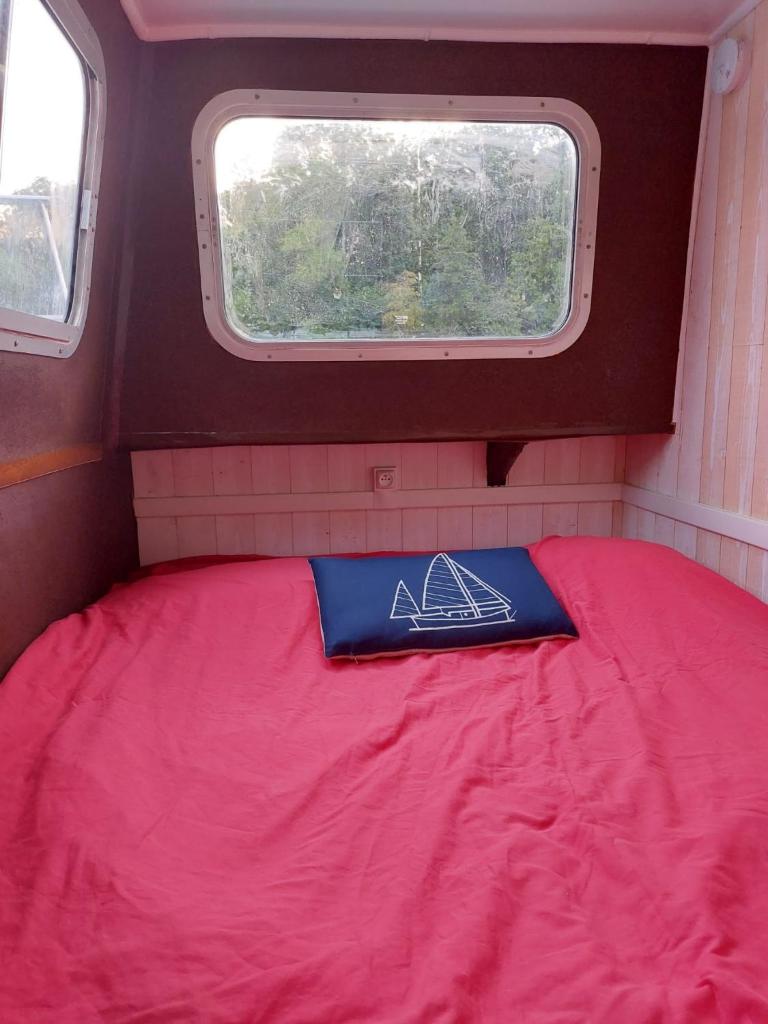 un lit dans une petite pièce avec une fenêtre dans l'établissement BOAT Judy proche PARIS, à Maurecourt