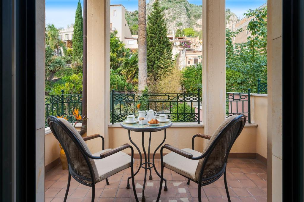 un balcon avec une table et des chaises et une vue dans l'établissement Hotel Villa Schuler, à Taormine
