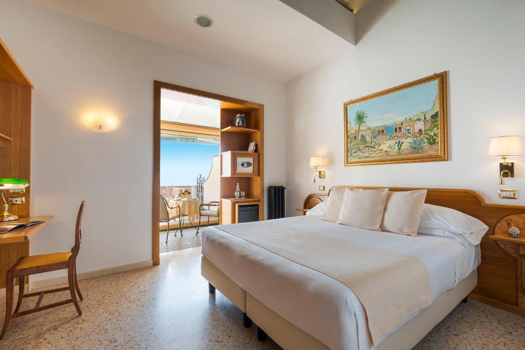 une chambre avec un lit, une table et une chaise dans l'établissement Hotel Villa Schuler, à Taormine 78 autres photos