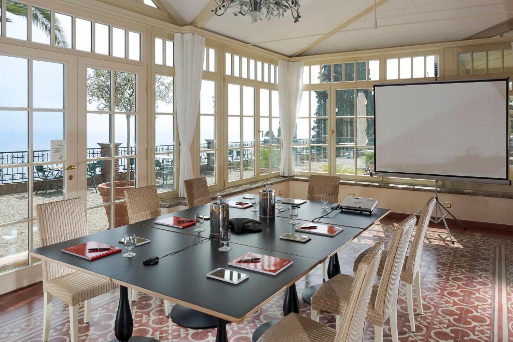 une salle de conférence avec une table et un écran dans l'établissement Hotel Villa Schuler, à Taormine