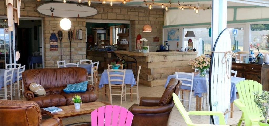 Il comprend un salon avec des chaises et des tables ainsi qu'une cuisine. dans l'établissement Camping Landrezac Plage, à Sarzeau