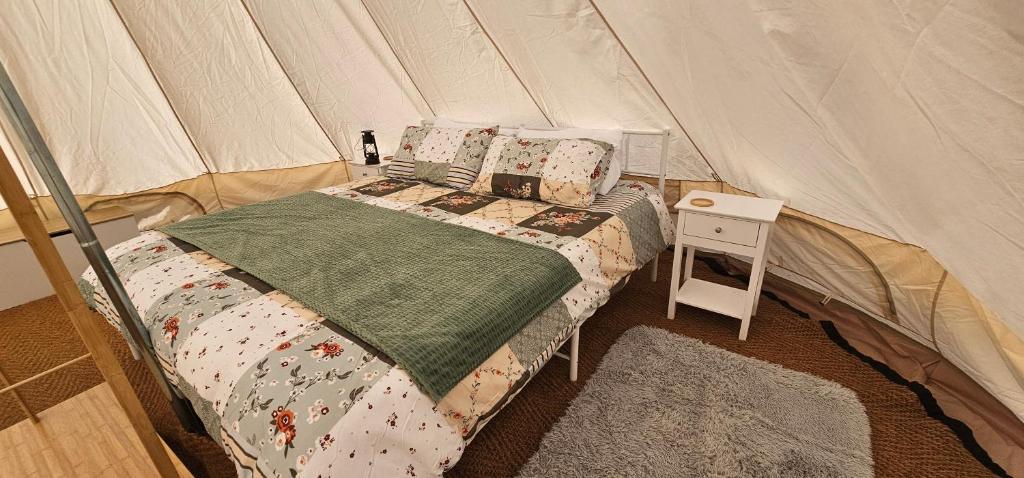 une chambre avec un lit dans une tente dans l'établissement Camping le Monteil, à Évaux-les-Bains