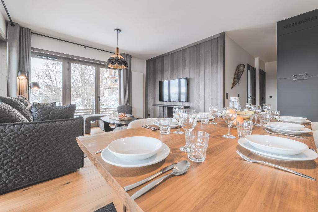 une salle à manger pourvue d'une table avec des assiettes et de l'argenterie dans l'établissement TERRESENS - Le Quartz - NEW, à Peisey-Nancroix