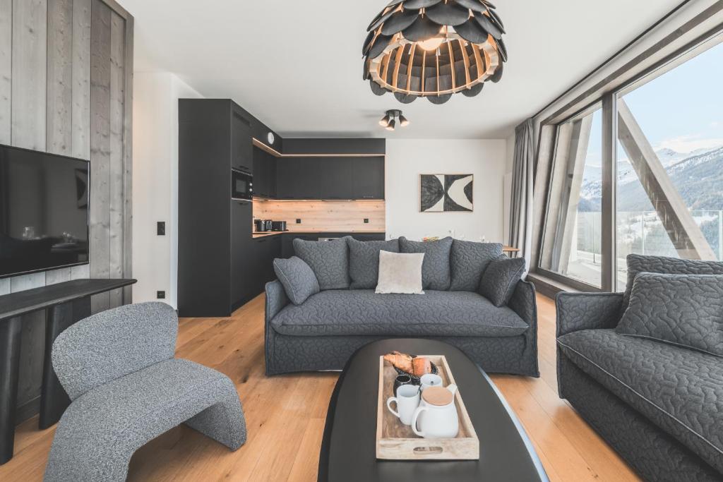 un salon avec un canapé et une chaise dans l'établissement TERRESENS - Le Quartz - NEW, à Peisey-Nancroix