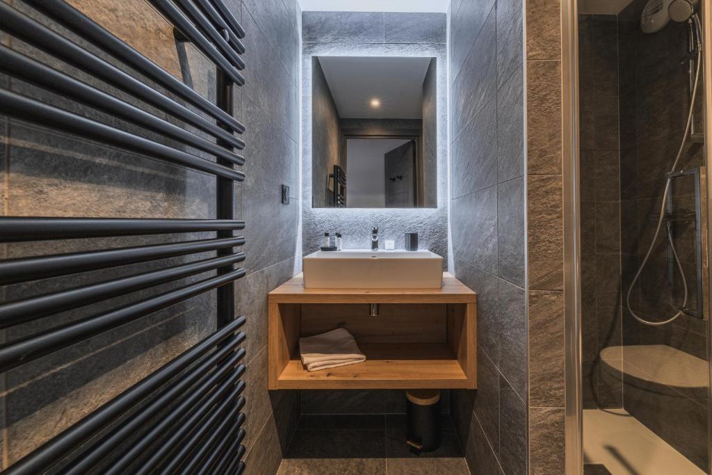 une salle de bain avec un lavabo et un miroir dans l'établissement TERRESENS - Le Quartz - NEW, à Peisey-Nancroix 37 autres photos