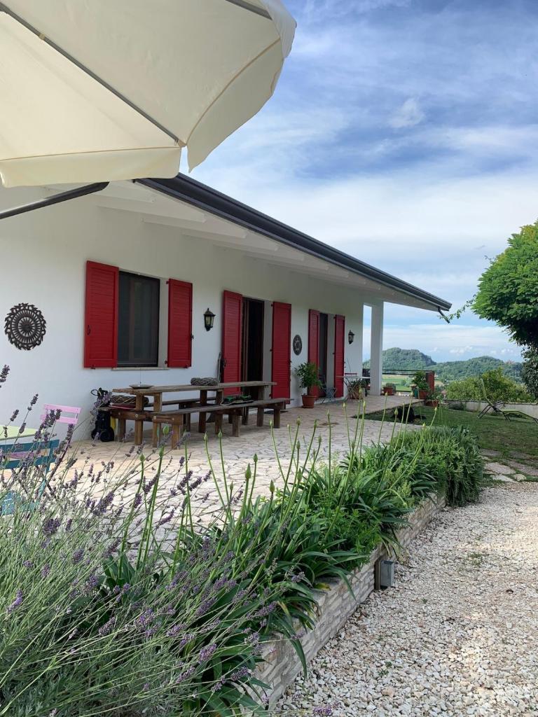 Cette maison dispose de volets rouges et d'une terrasse. dans l'établissement Holiday home with alpine panorama, à Teolo 39 autres photos