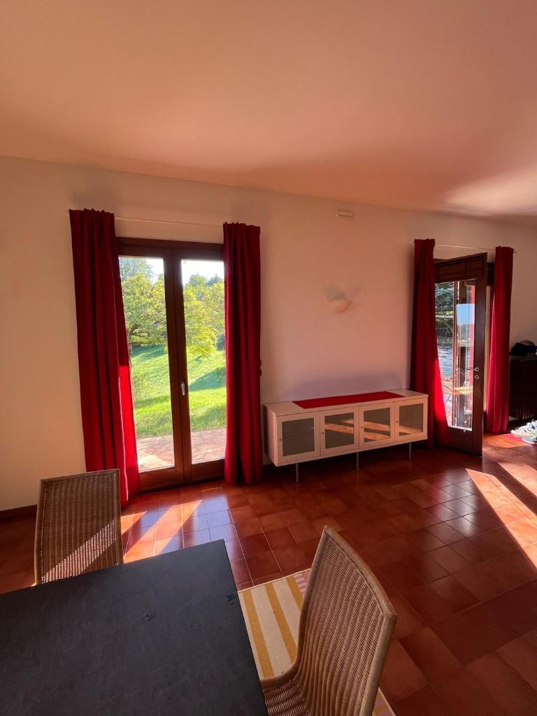 - un salon avec des rideaux rouges, une table et des chaises dans l'établissement Holiday home with alpine panorama, à Teolo