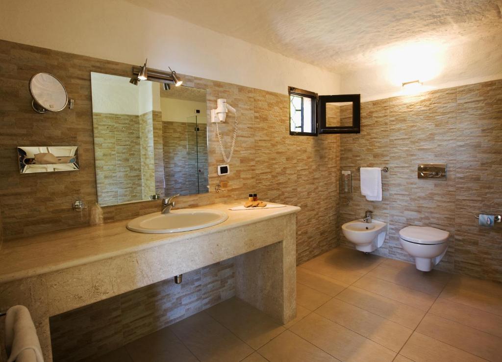 une salle de bain avec un lavabo et des toilettes dans l'établissement Hotel Don Diego, à Porto San Paolo