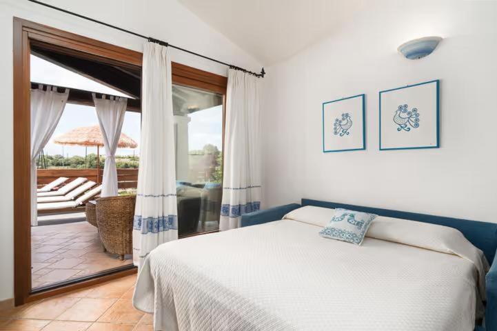 - une chambre avec un lit et une vue sur une terrasse dans l'établissement Villa Luna, à Tanaunella