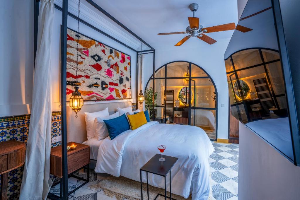 une chambre avec un lit et un ventilateur de plafond dans l'établissement Maison H Kasbah, à Marrakech