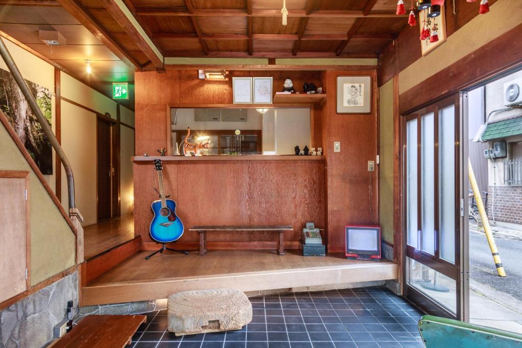 Cette chambre comprend un banc et une guitare. dans l'établissement Yadoya Hiraiwa, à Kyoto