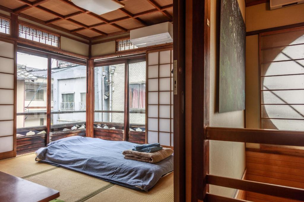 Cette chambre dispose d'un lit et de fenêtres. dans l'établissement Yadoya Hiraiwa, à Kyoto