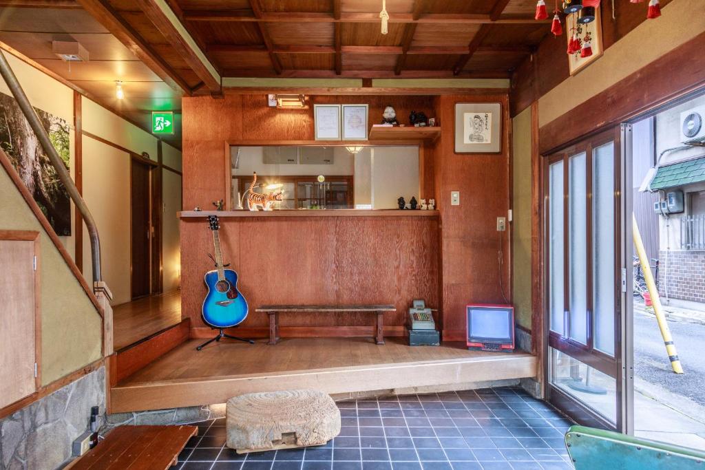 Cette chambre comprend un banc et une guitare. dans l'établissement Yadoya Hiraiwa, à Kyoto