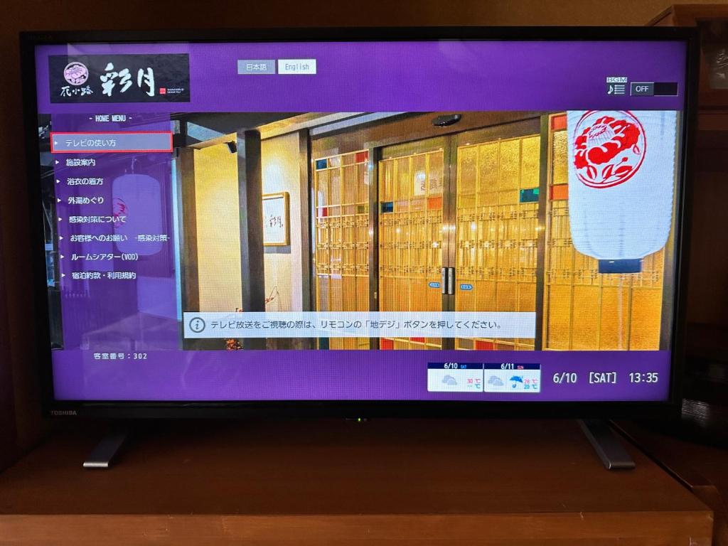 un écran de télévision avec une photo d'un bâtiment dans l'établissement Kinosaki Onsen Hanakouji Saigetsu, à Toyooka