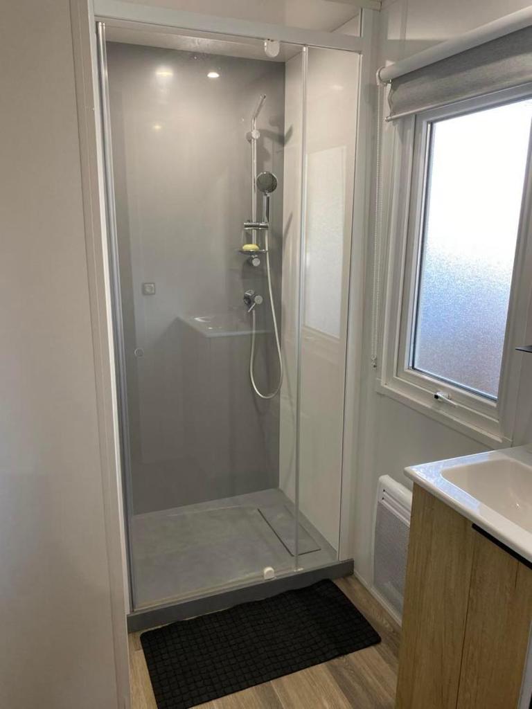 une douche en verre dans une salle de bain avec un lavabo dans l'établissement Mobile-Home 6 pers Camping 4 Etoiles 66140 Idéal Familles, à Canet