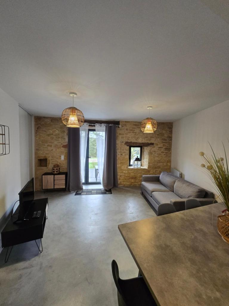 un salon avec un canapé et une table dans l'établissement Gîte Les Combes Montignac Lascaux, à Montignac