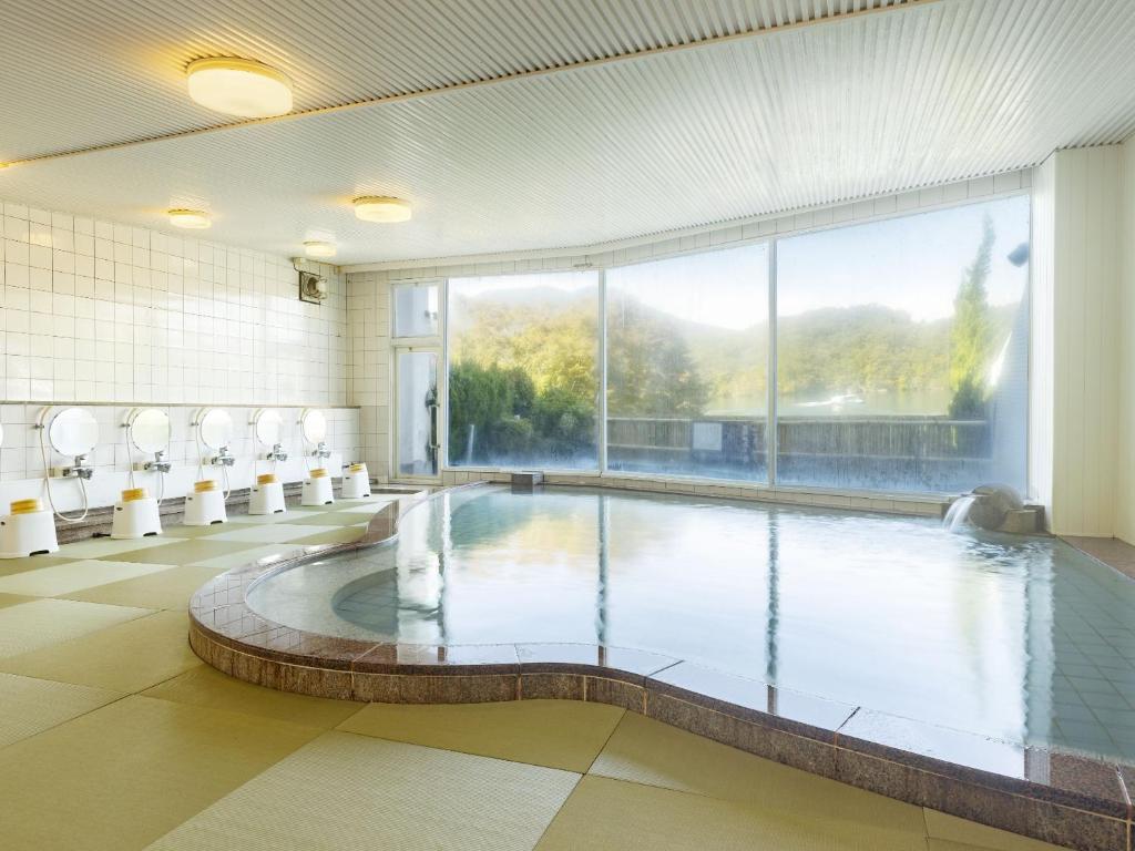 une grande piscine dans un immeuble avec une grande fenêtre dans l'établissement Ooedo Onsen Monogatari Enakyo, à Ena