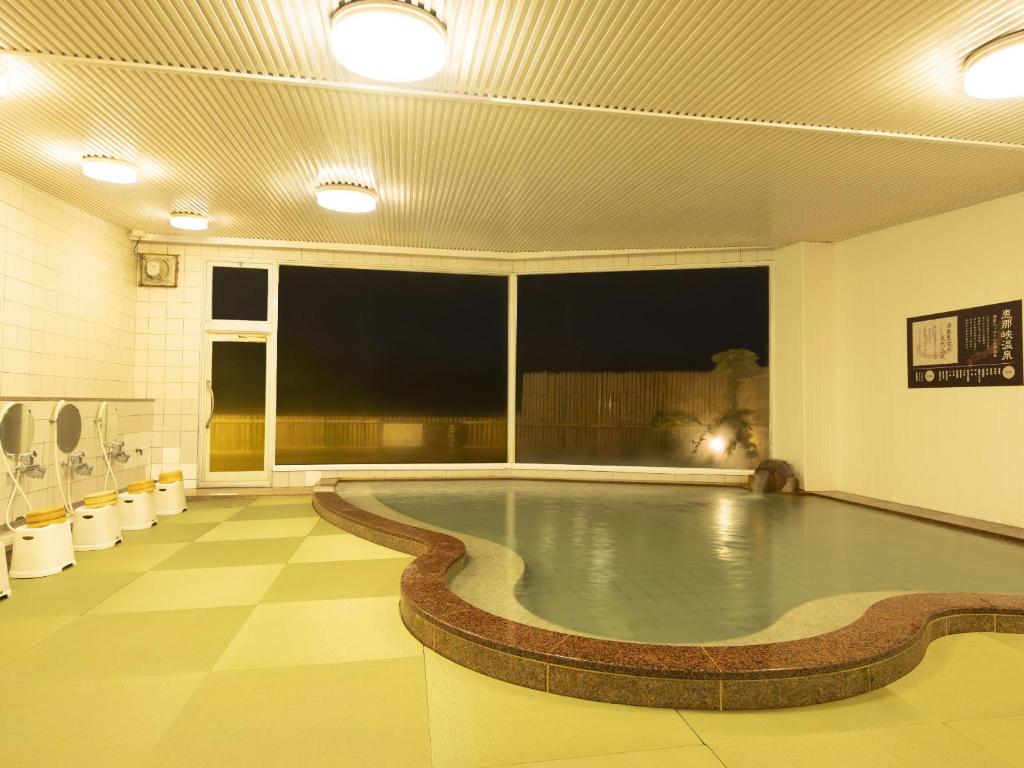 - une piscine dans une salle de sport dotée d'une grande fenêtre dans l'établissement Ooedo Onsen Monogatari Enakyo, à Ena