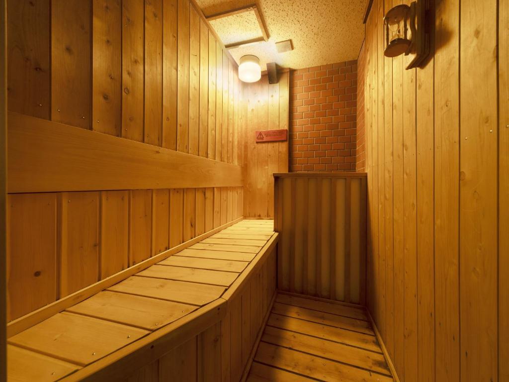un sauna avec des boiseries et une lumière sur le mur dans l'établissement Ooedo Onsen Monogatari Shima Saichoraku, à Shima