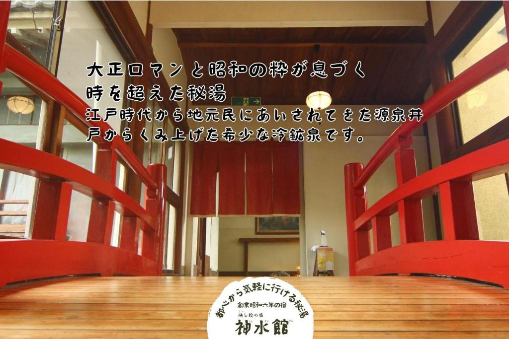 une table avec des chaises rouges et un panneau sur celle-ci dans l'établissement 神水館 都心から気軽に行ける秘湯, à Fujioka 37 autres photos
