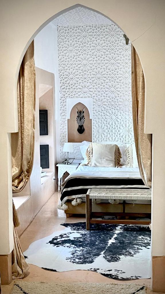 - une chambre avec un lit avec une arche dans l'établissement Riad Chocolat, à Marrakech