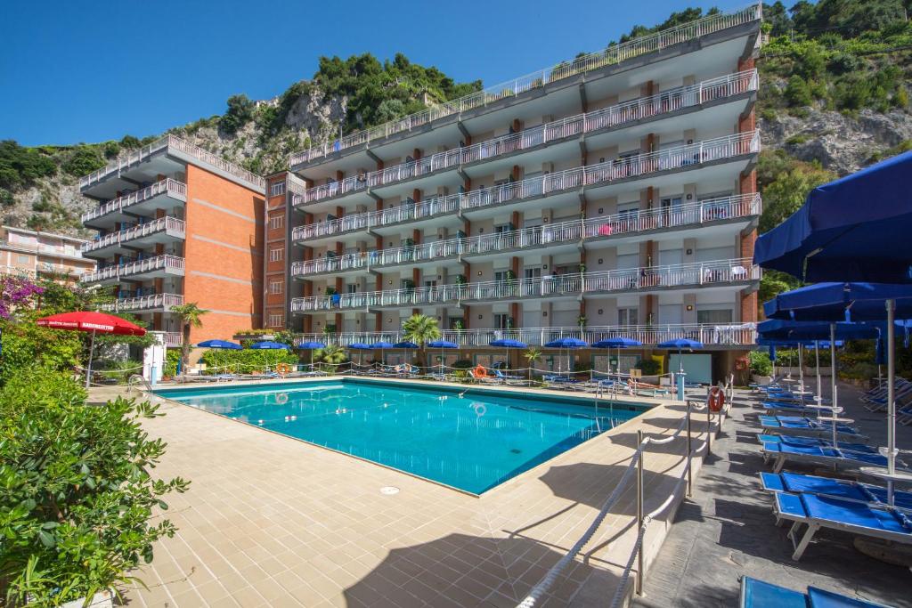 un hôtel avec une piscine dotée de chaises et de parasols dans l'établissement Angelina Residence, à Maiori