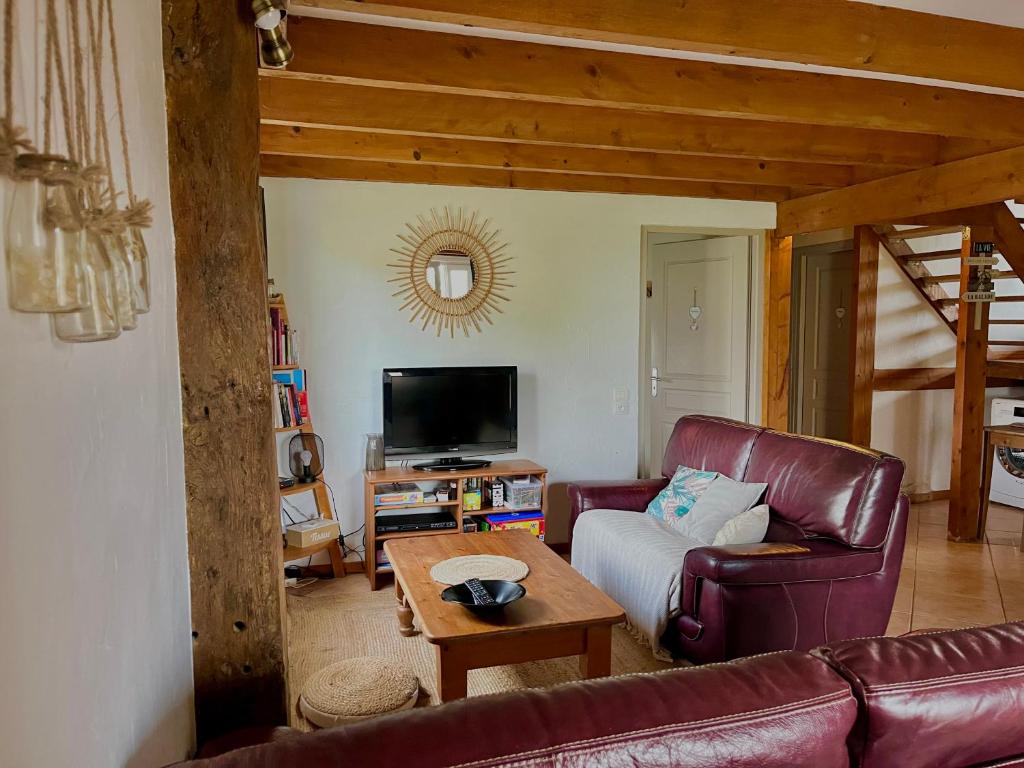 un salon avec un canapé et une table dans l'établissement Gites de Nicou - L'Auvent, à Monflanquin