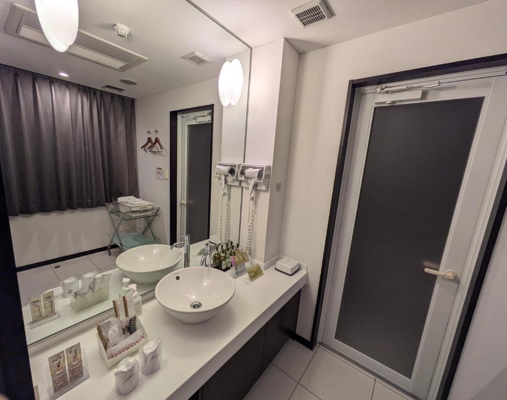 une salle de bain avec un lavabo et un grand miroir dans l'établissement ホテル リズコート HOTEL Liz court, à Sendai 31 autres photos