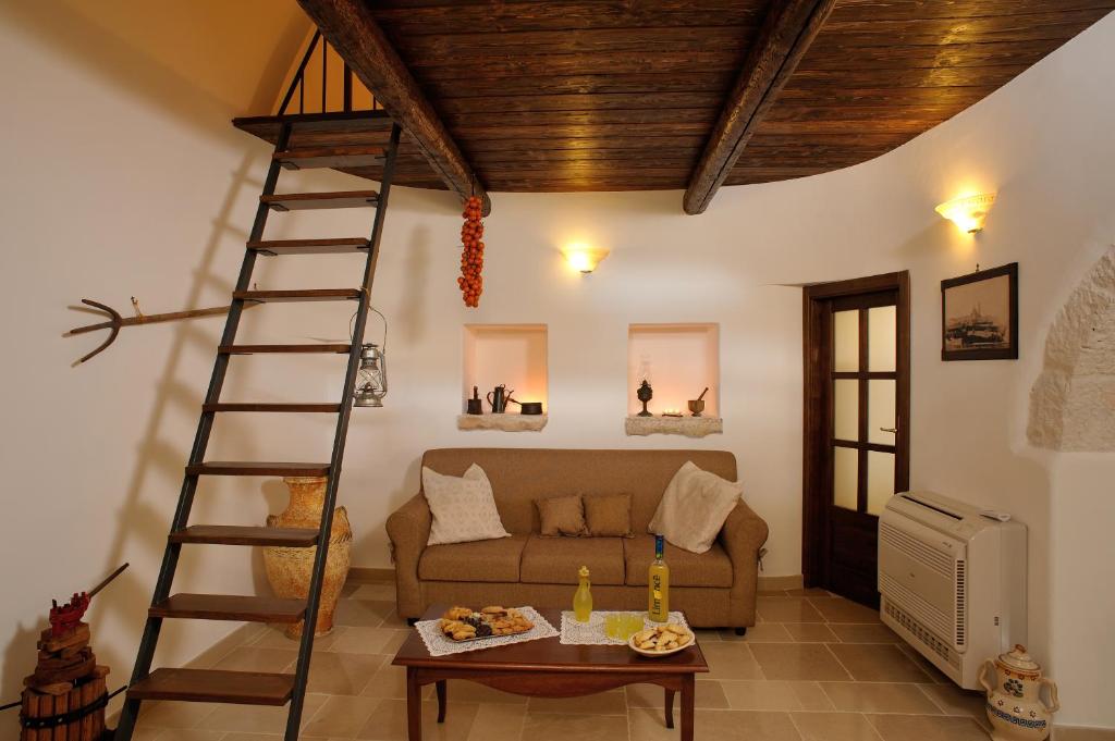un salon avec une échelle et un canapé dans l'établissement Trulli, à Martina Franca