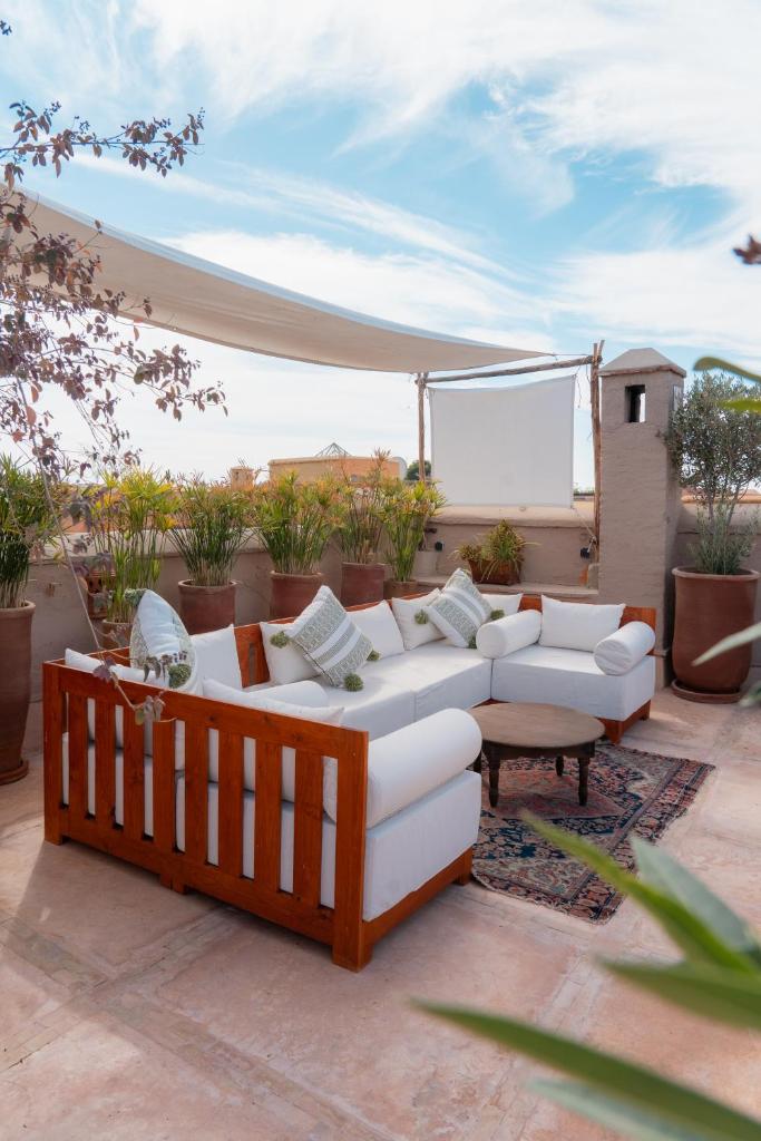 une terrasse avec des canapés blancs et une table basse dans l'établissement Riad Dar Dounia, à Marrakech