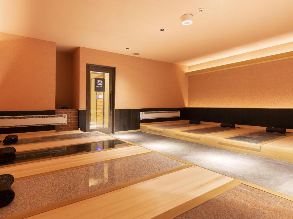 une pièce vide avec des risers en bois et une porte dans l'établissement Ooedo Onsen Monogatari Premium Saiki Bekkan, à Misasa