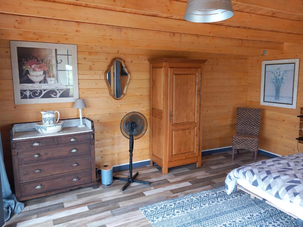 une chambre avec un lit et un mur en bois dans l'établissement Chalet chez le breton des marais, à Bouin