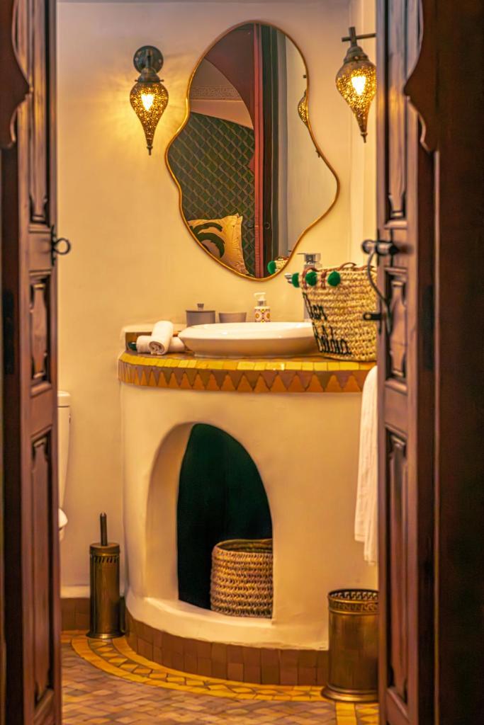 une salle de bain avec un lavabo et un miroir dans l'établissement Riad Dar Beldia and Spa, à Marrakech
