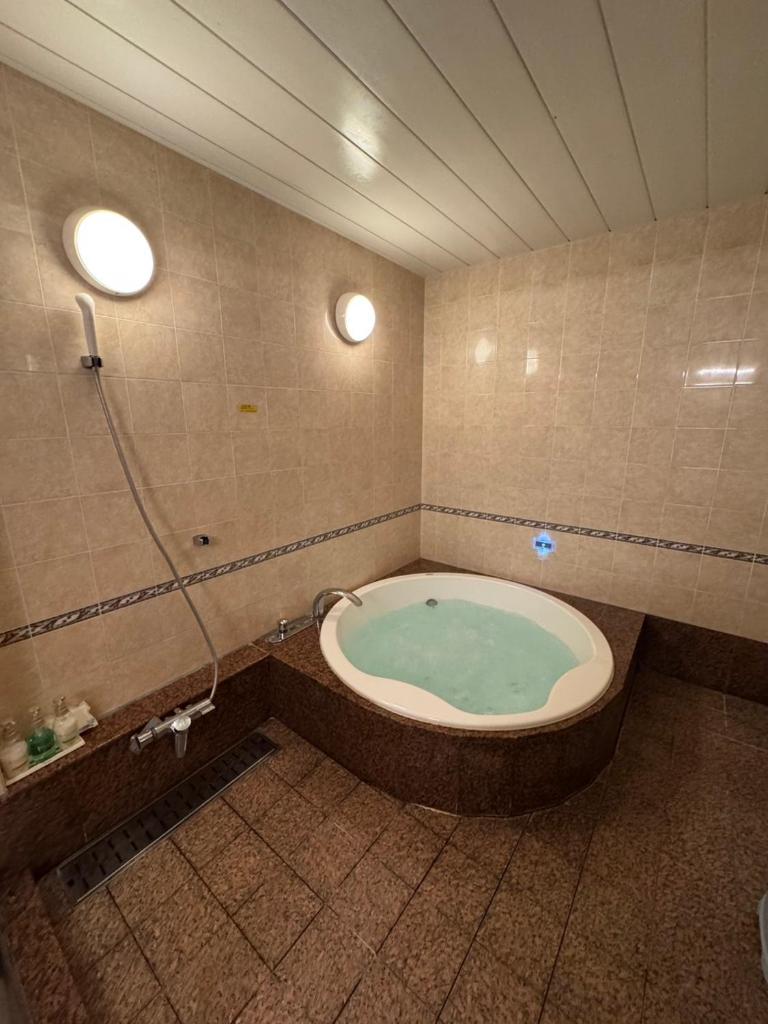 une salle de bain avec baignoire et douche dans l'établissement Tongariboshi (Adult Only), à Sakaide