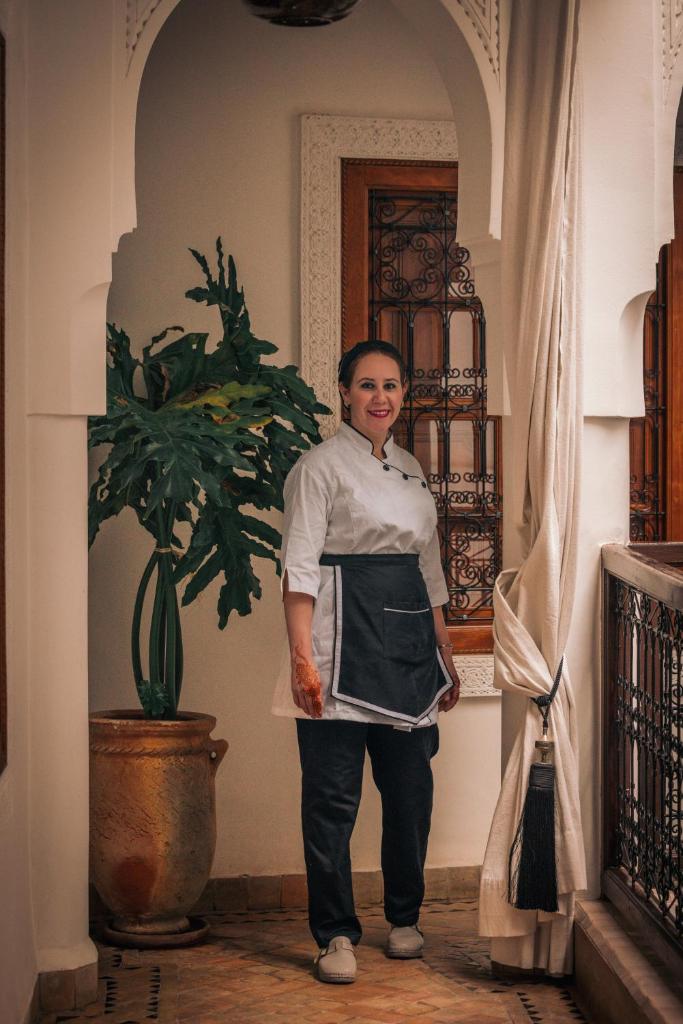 une femme debout dans un couloir avec une plante dans l'établissement Riad Dar Beldia and Spa, à Marrakech 37 autres photos