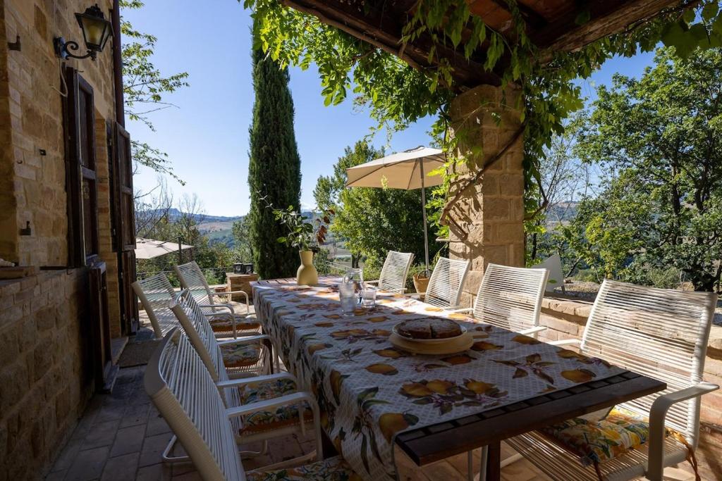Une table à manger et des chaises sont disponibles sur la terrasse. dans l'établissement Casa Santo Stefano, à San Girolamo di Sopra