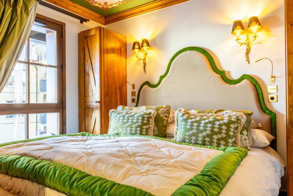 - une chambre dotée d'un lit vert et blanc avec des oreillers dans l'établissement ARC 1950 Ovis D'Or, view Mont Blanc, à Arc 1950