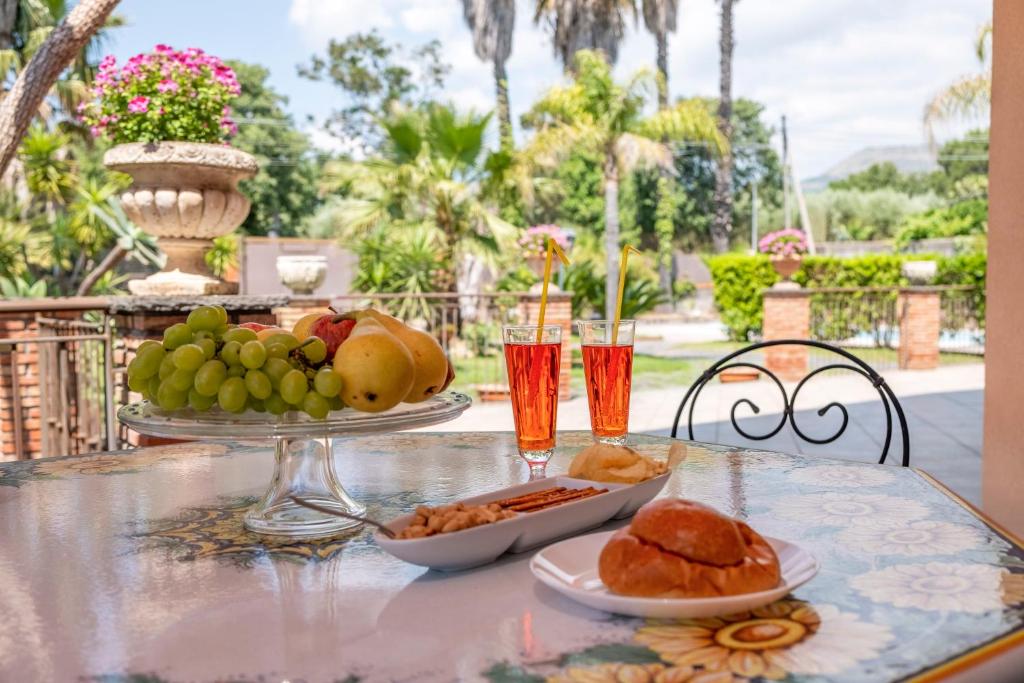 - une table avec une assiette de nourriture et de boissons dans l'établissement Villa Etna da mare, à Fleri
