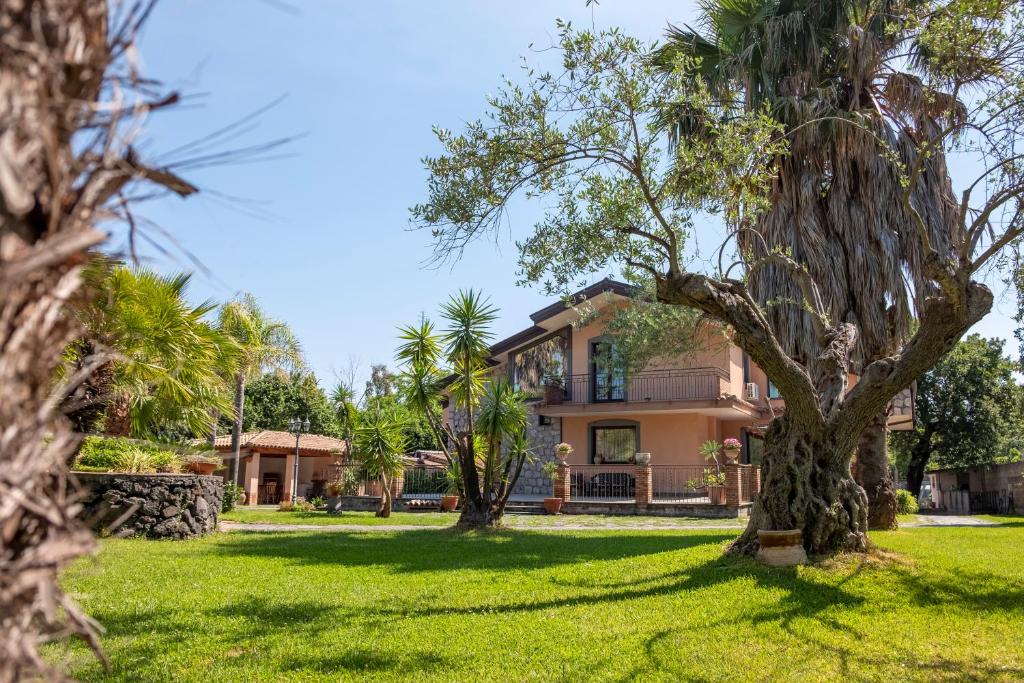 une maison avec des palmiers devant dans l'établissement Villa Etna da mare, à Fleri