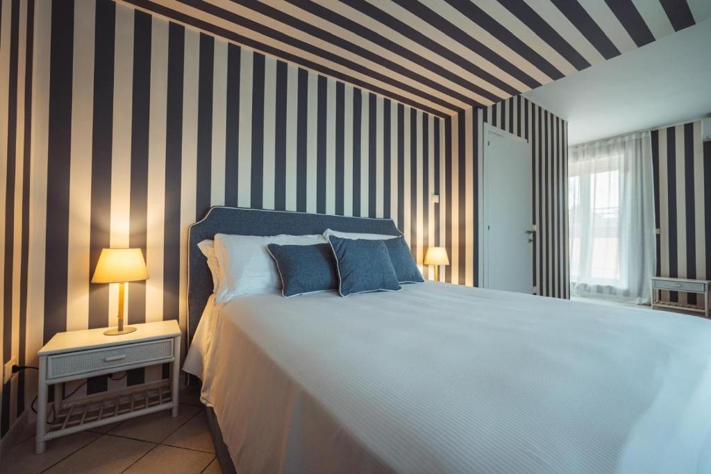 - une chambre avec un grand lit et un mur rayé dans l'établissement MareLuxe & Pool, à Polignano a Mare