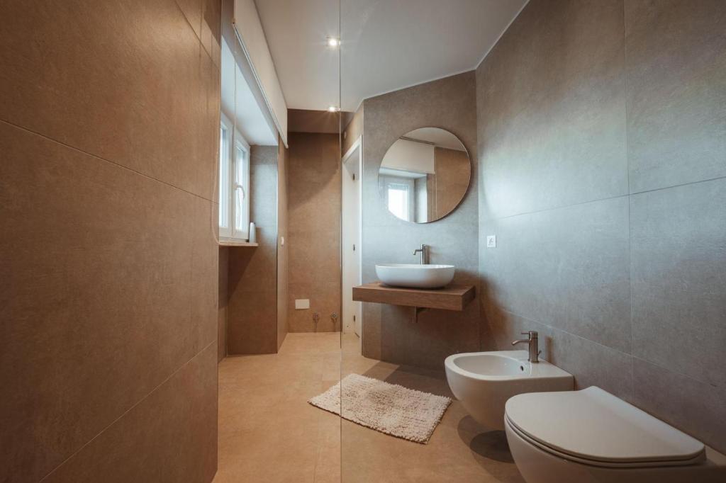une salle de bain avec un lavabo, des toilettes et un miroir dans l'établissement MareLuxe & Pool, à Polignano a Mare
