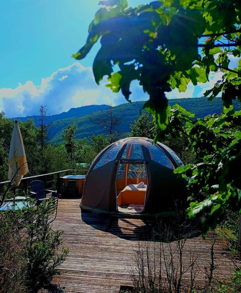 une tente installée au-dessus d'une terrasse en bois dans l'établissement Bulle en bois sous les étoiles, à Champfromier